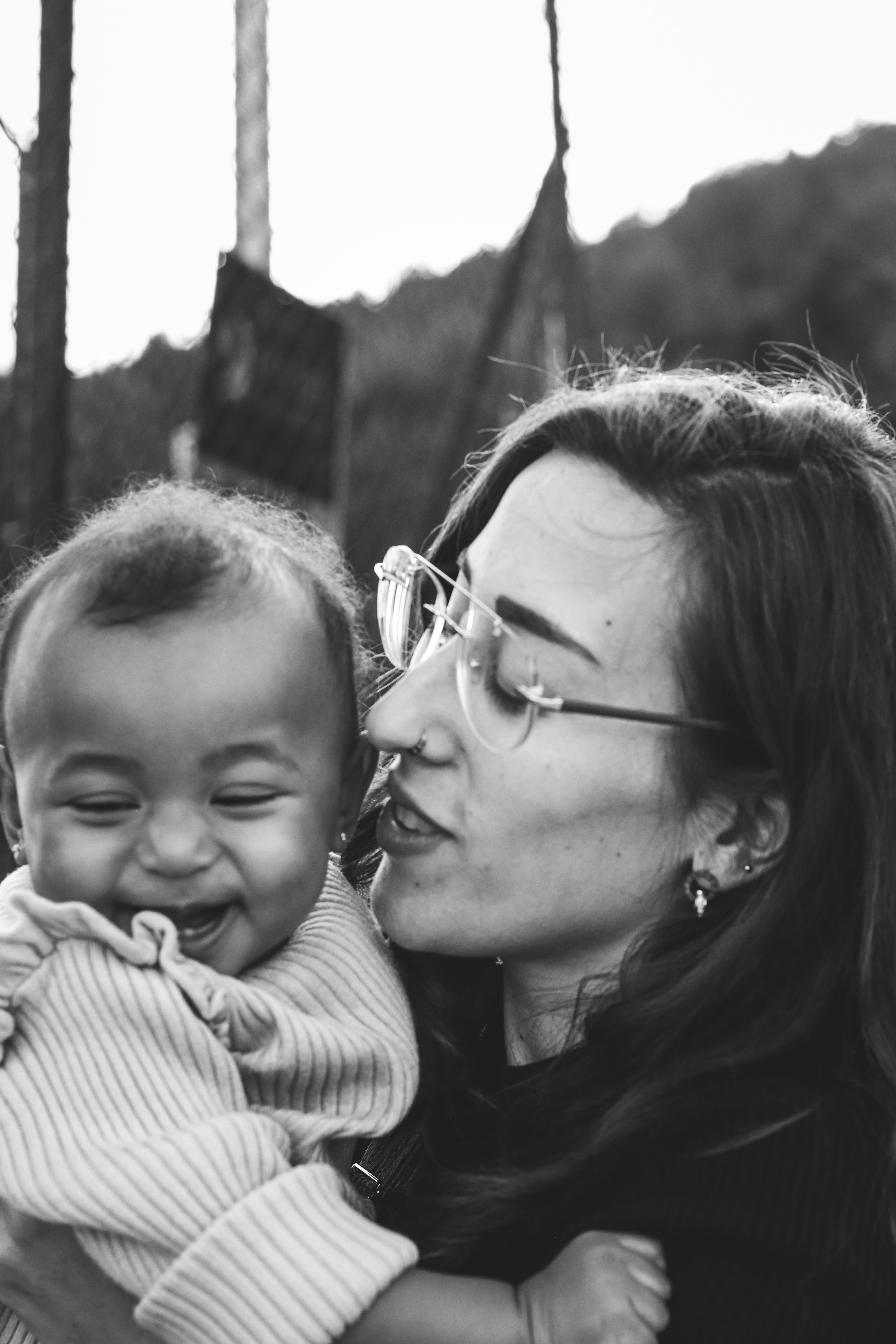 A mother kissing her laughing baby's cheek