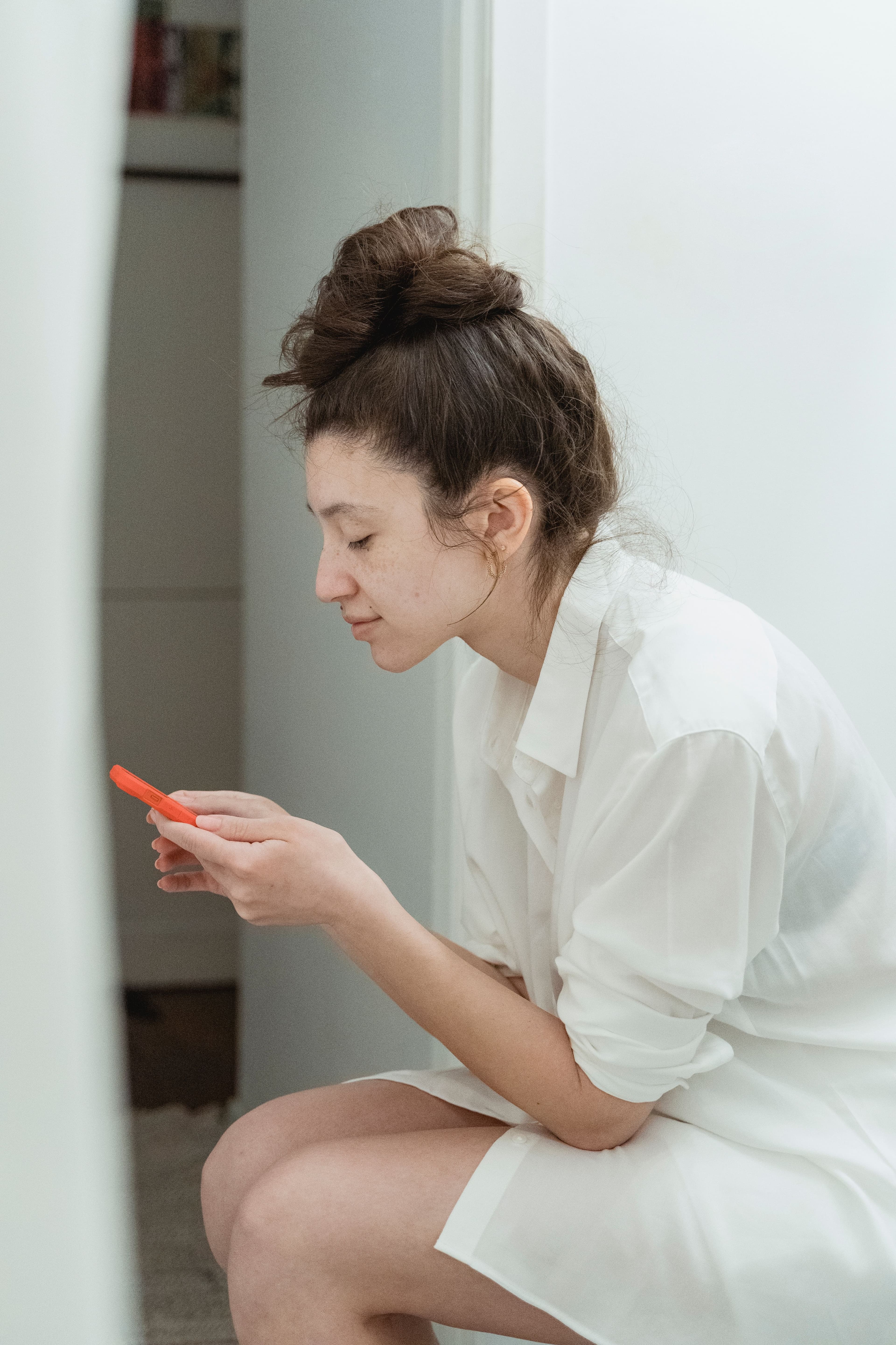 A woman sitting quietly, looking down at a pregnancy test