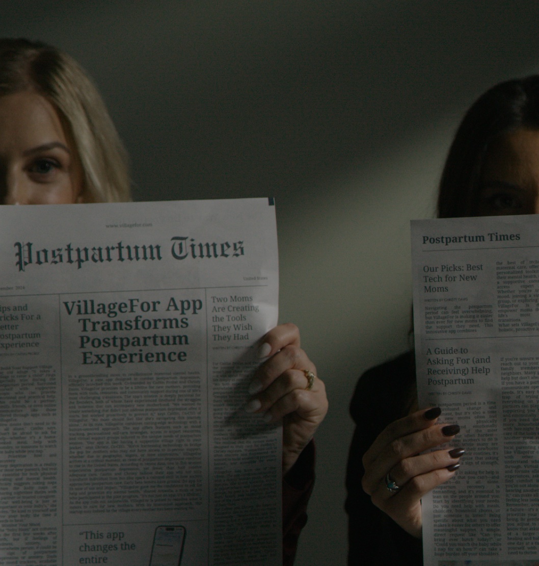 VillageFor co-founders holding up mock newspapers reading "Postpartum Times"