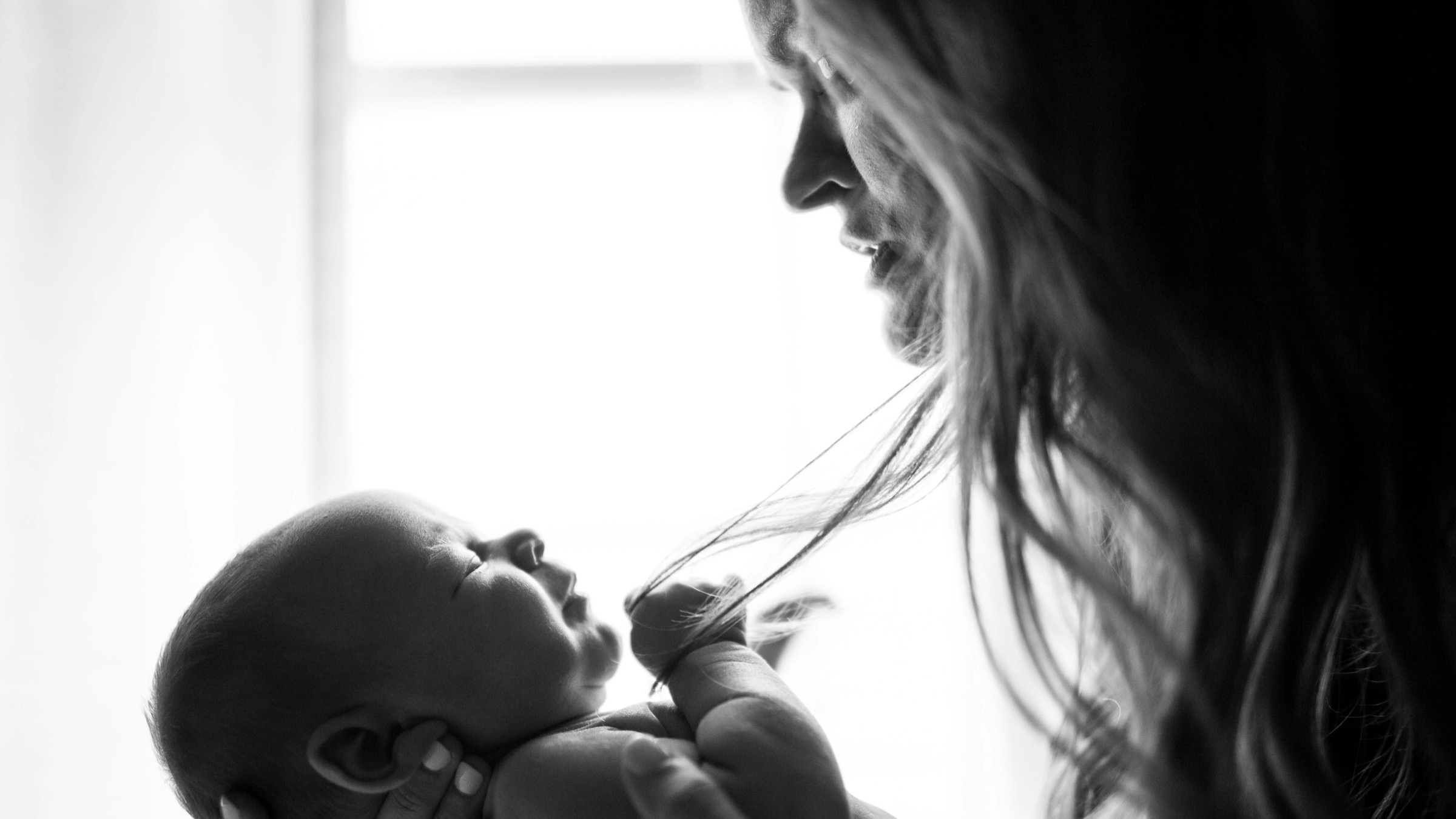 Black and white photo of a mother holding her baby close