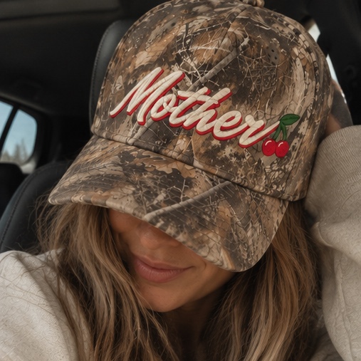 A woman in a car wearing the Mother Hat pulled low over her eyes
